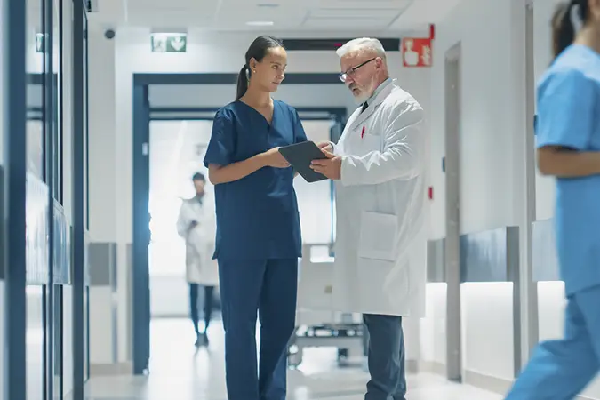 Medical staff standing in a hospital hallway discussing medical payment processing and patient payments