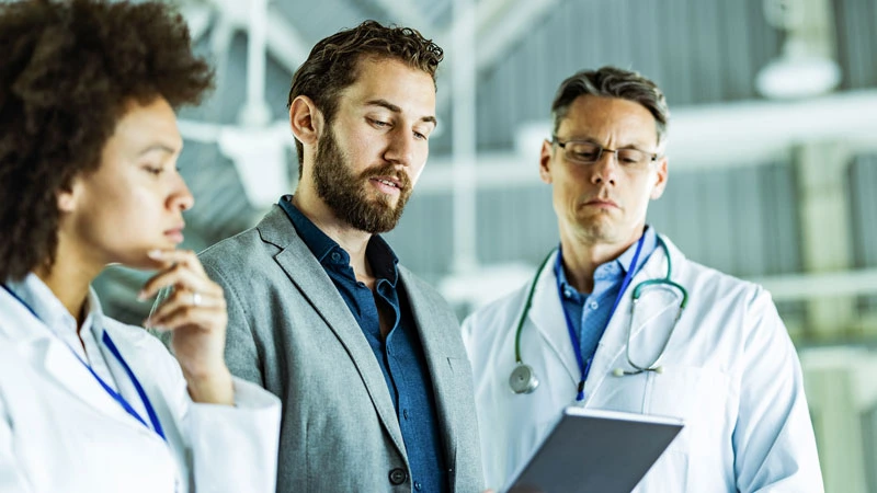 Healthcare administrators meeting in office to discuss healthcare RCM technologies and automation possibilities.