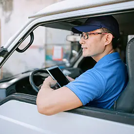 Business man looking at tablet outside vehicle.