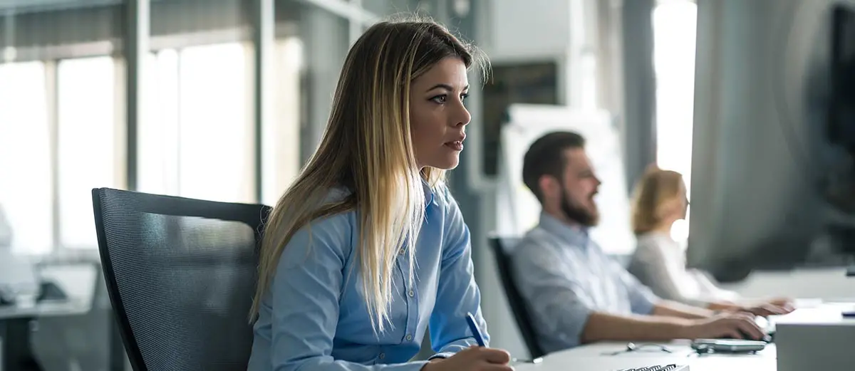 Woman sitting in her office writing down information about payment fraud