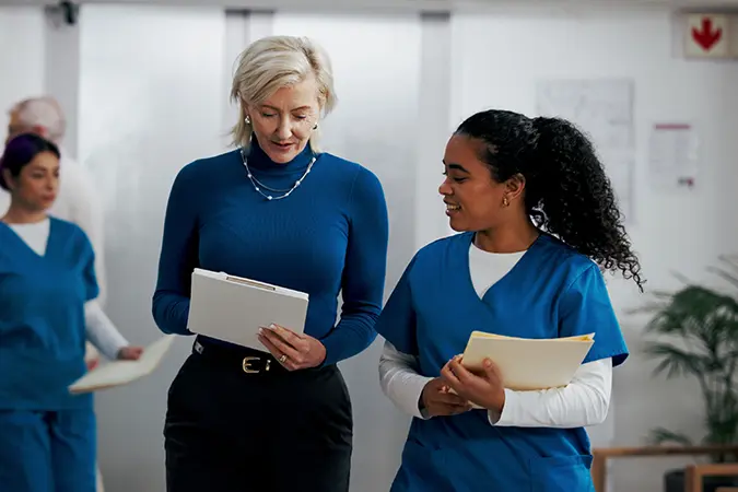Health insurance agent and nurse discussing medical payment processing and claim payments