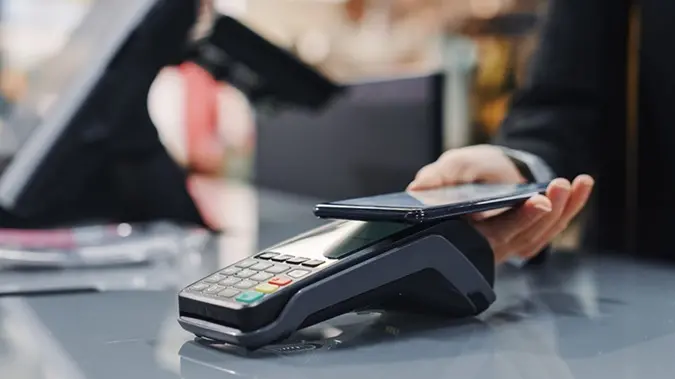 Person using cell phone to tap and pay at a store photo-hot-topic-3x2.jpg  