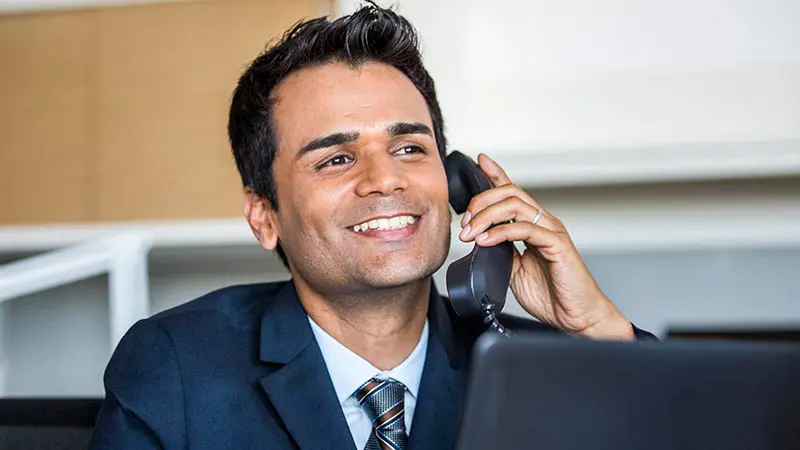 Man on phone discussing cybersecurity best practices and technology for bank security.