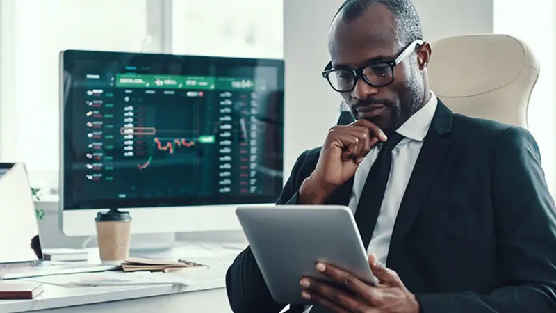 Man sitting looking at laptop comparing VAM capabilities and providers in banking and finance.
