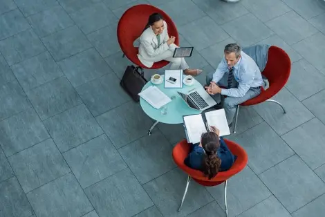 Overhead view of 3 professionals around a small table