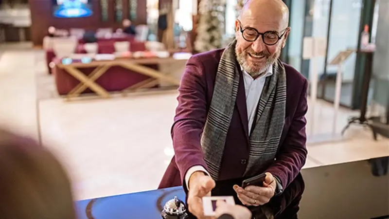 Person holding mobile device to a point of sale reader using virtual payments