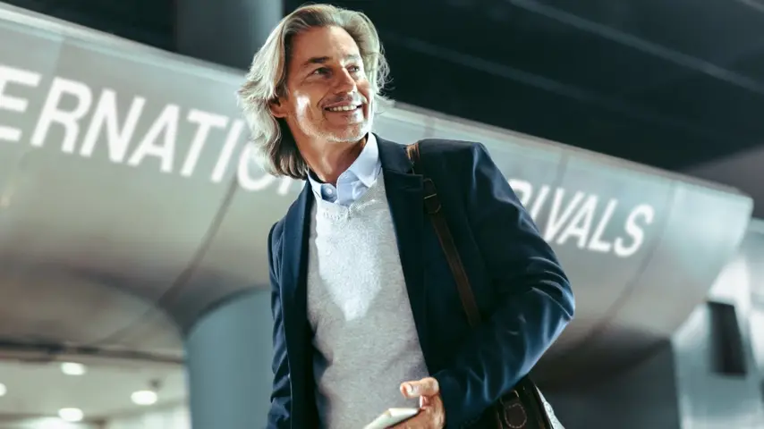 Person at airport smiling after using his U.S. Bank Corporate Card.