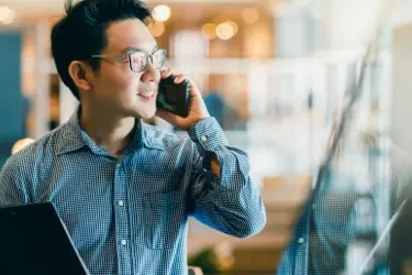 A person smiling and talking on their mobile phone 