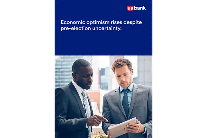 Two men in suits standing and talking in an office