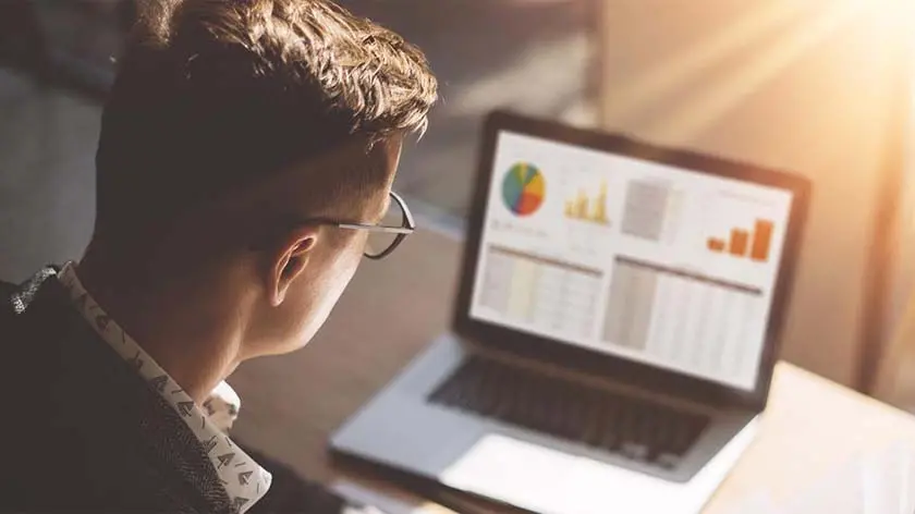 Man looking at trading charts on his laptop