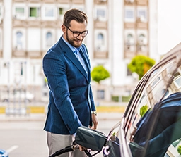 Business man fueling a car. 