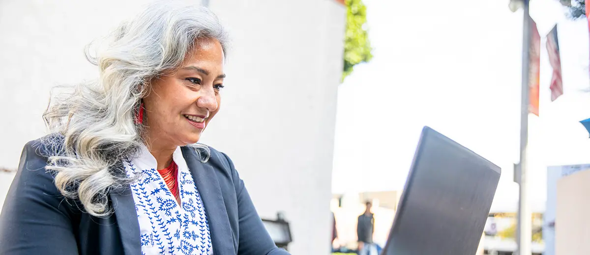 Woman in a business suit browsing on her laptop