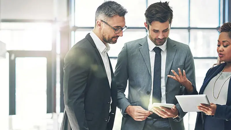 Three professionals standing and discussing marketplace lending