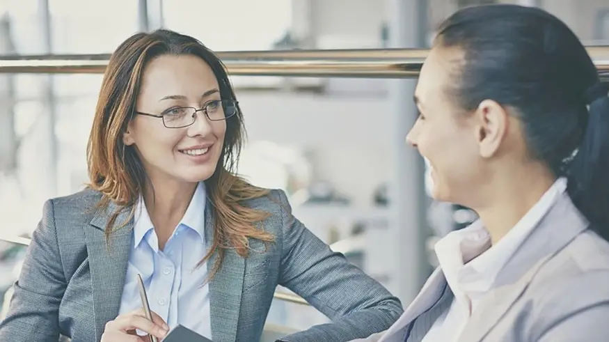 Two professional women discussing fund administration