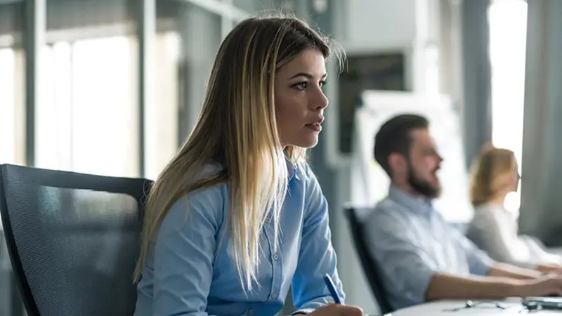 Business woman writing notes in a meeting