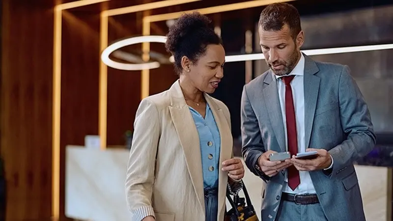 Professional colleagues checking in a hotel lobby checking in at the desk