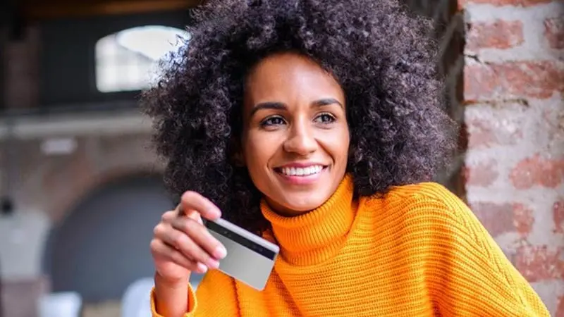 Woman holding her prepaid card that disburses government funds.
