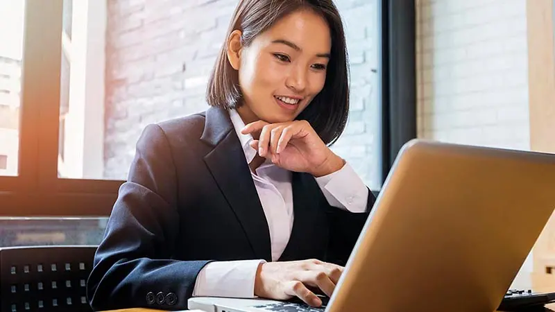 Business woman looking up the us bank swift code on her laptop.