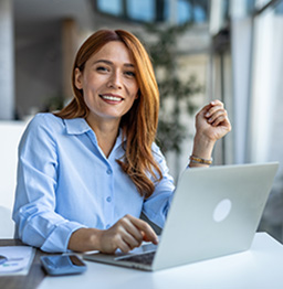 Woman reviewing freight reports on a laptop.