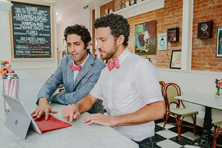 ice cream shop owners looking at tablet