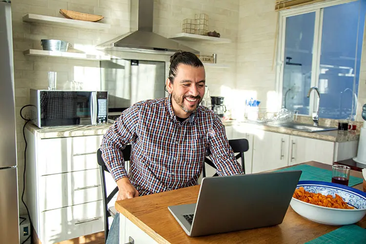 Male working on laptop in kitchen