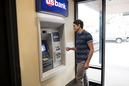 Man in ATM holding bank card