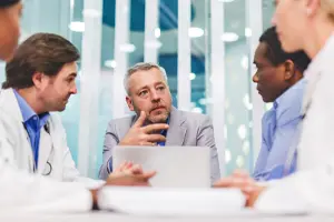 Five people in a business meeting room in a healthcare office