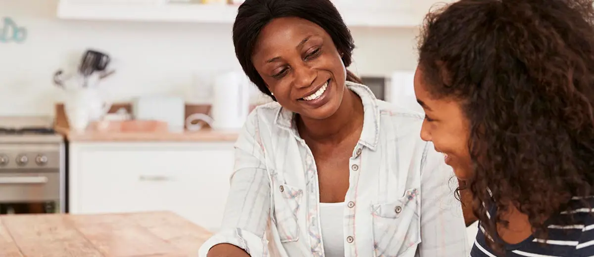 a woman in a white shirt smiling at her daughter