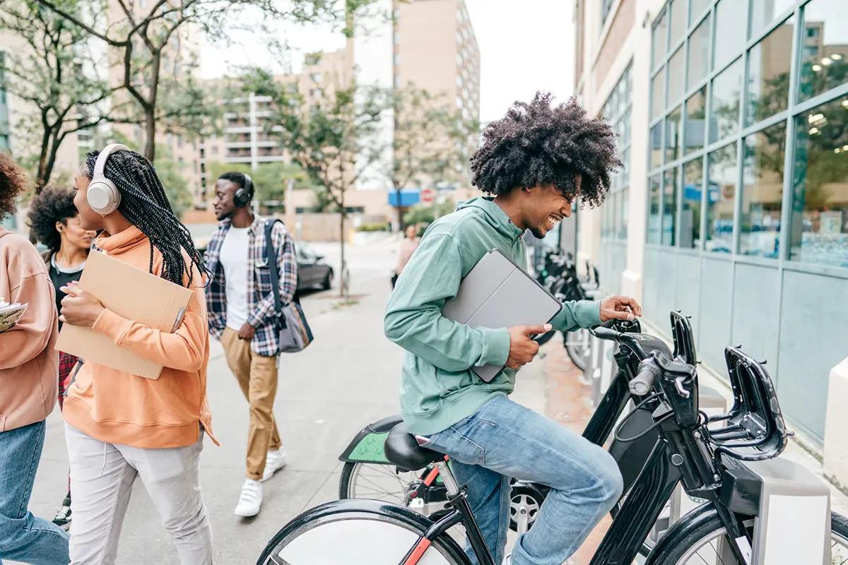 a man in a green sweatshirt sitting on an ebike