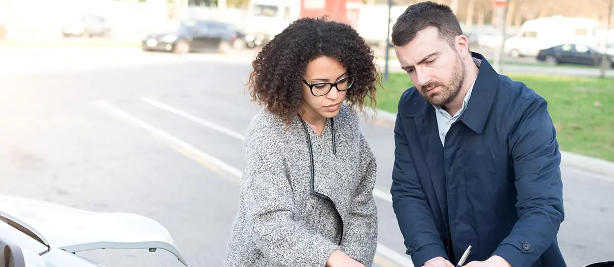 a man and a woman looking at the exterior of a car