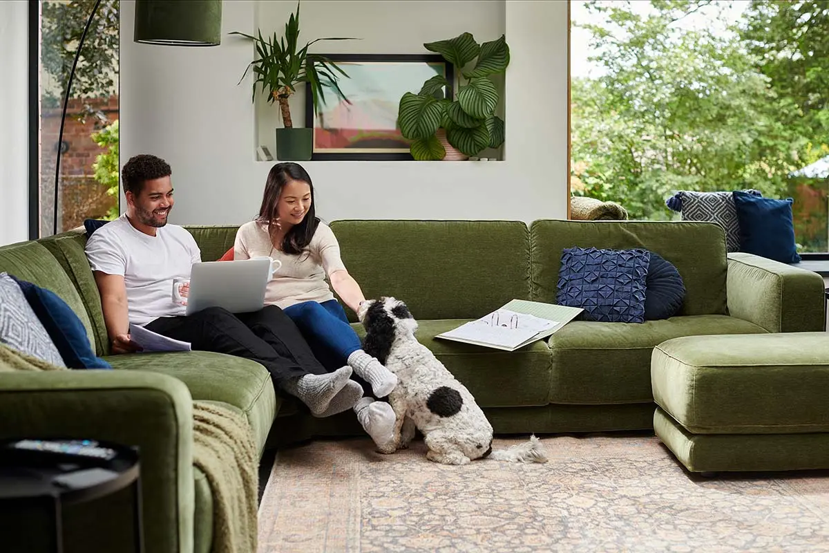 Couple relaxing on their couch with their dog nearby
