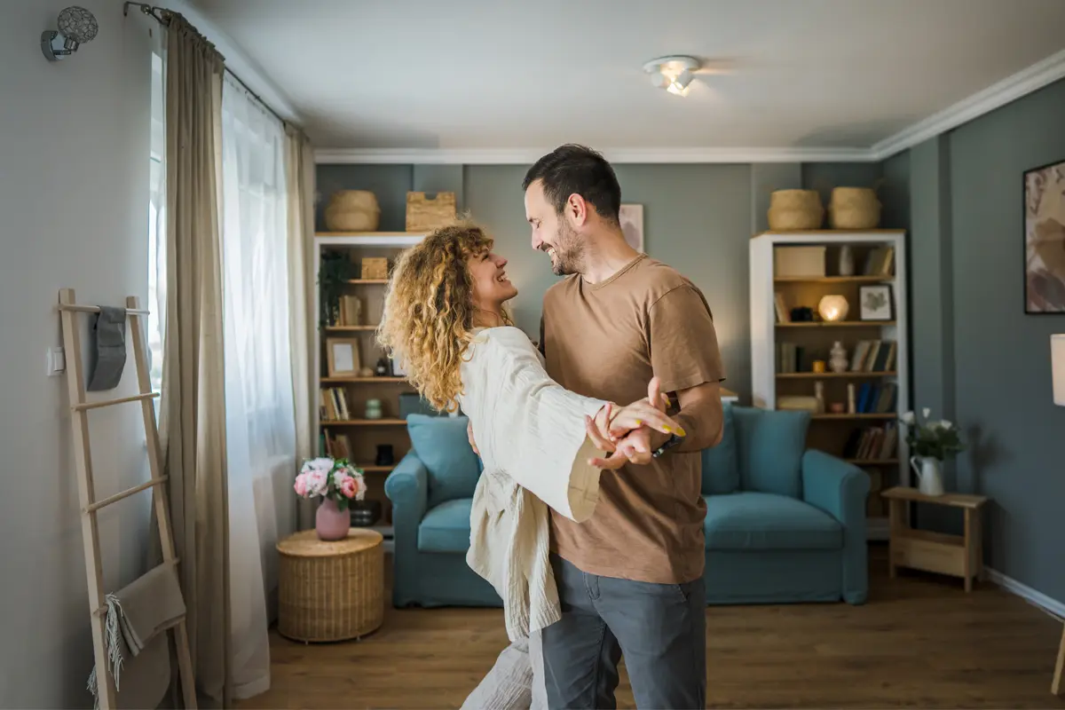 man and woman dancing in a living room