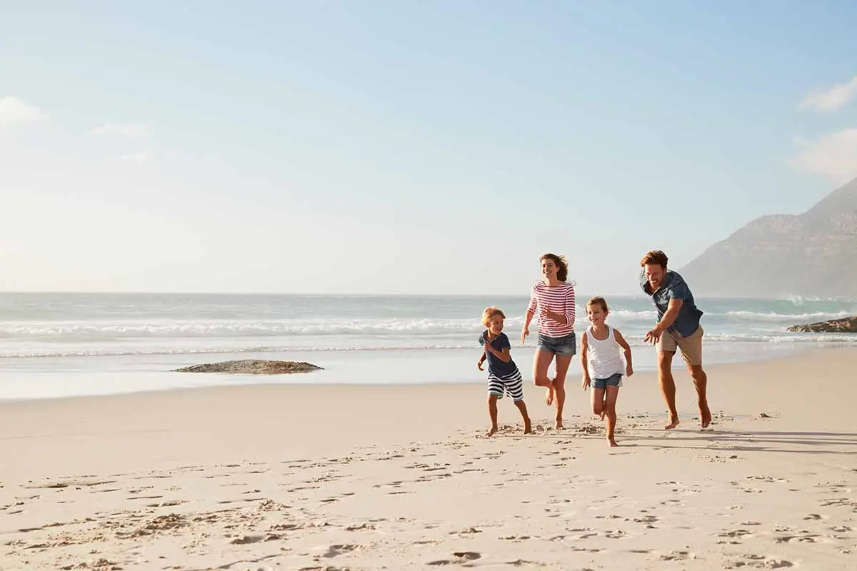 young family running on the beach