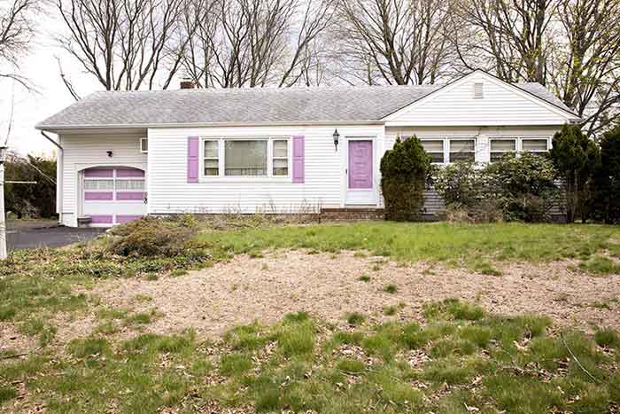 a white house with purple shutters and accents