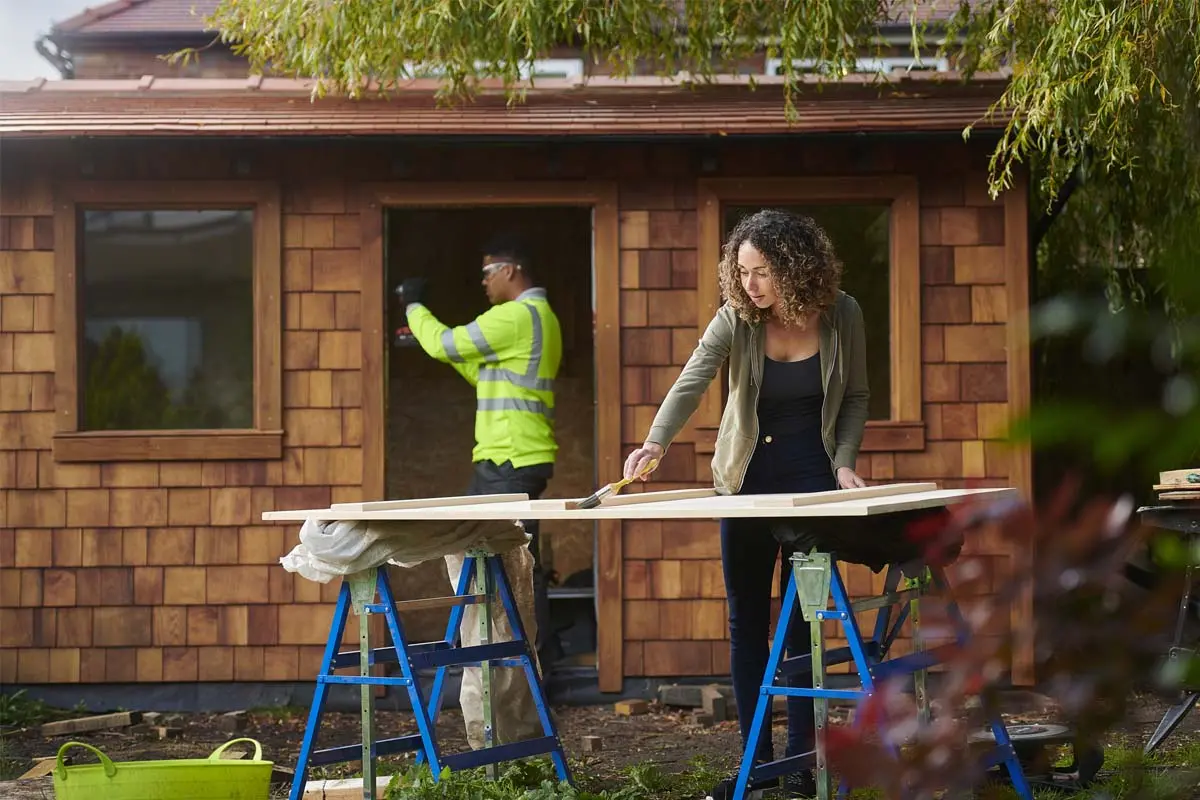 Woman painting door for outdoor living space.