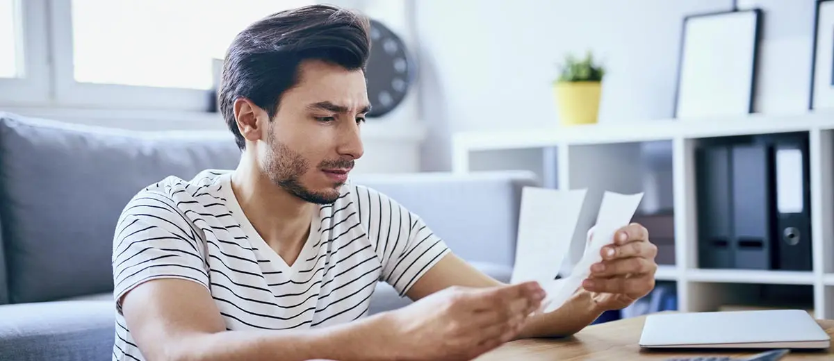 man in a striped shirt looking at his budget