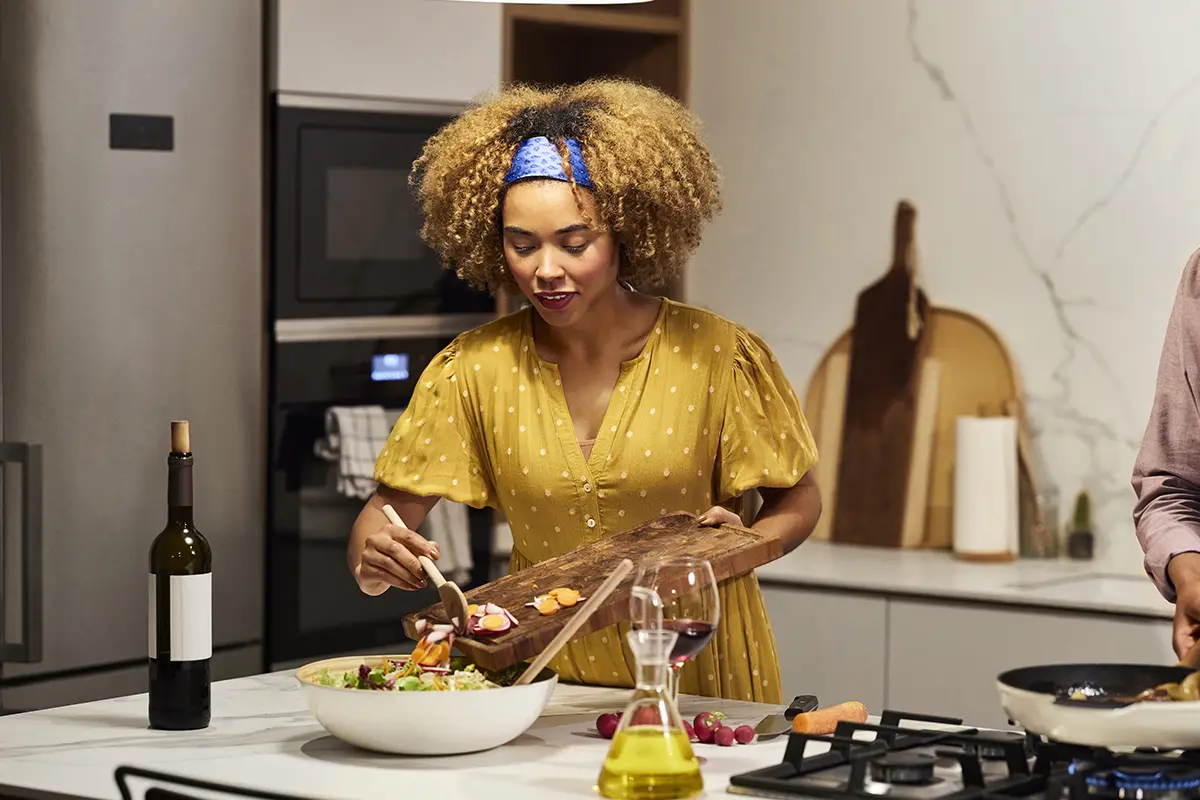 woman in a yellow dress making a salad