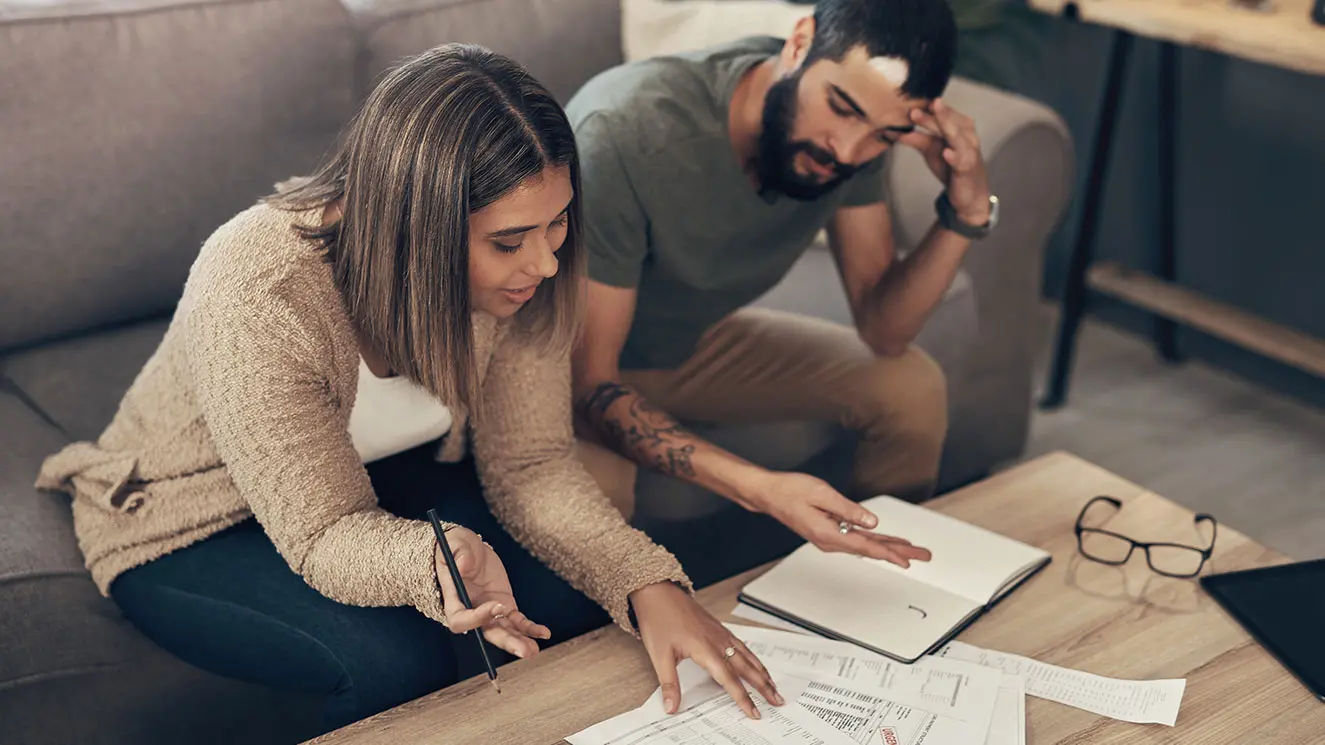 two people on a couch reviewing paperwork
