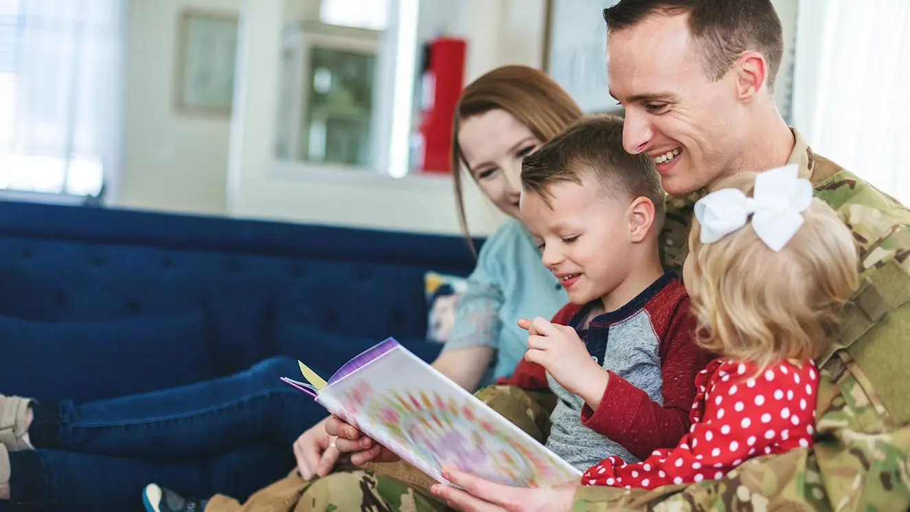 a man and woman read to their children
