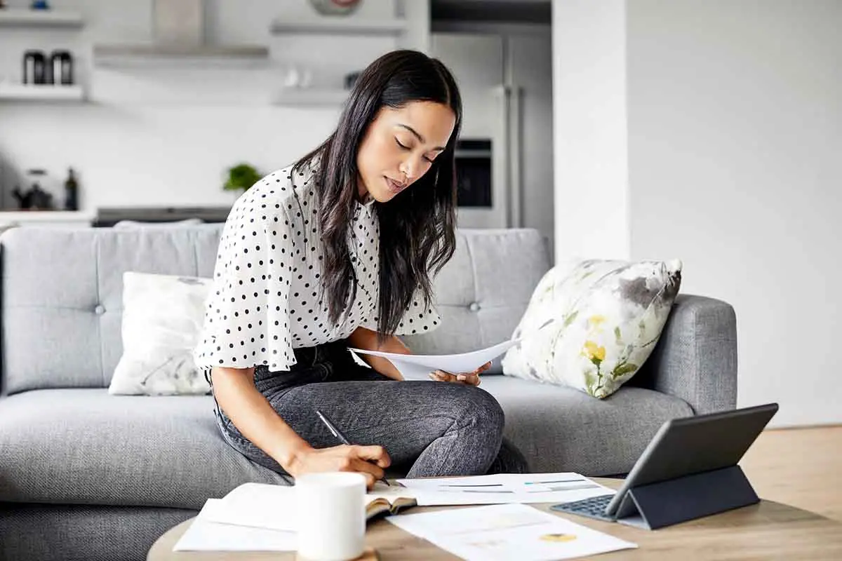 young woman doing taxes in her living room