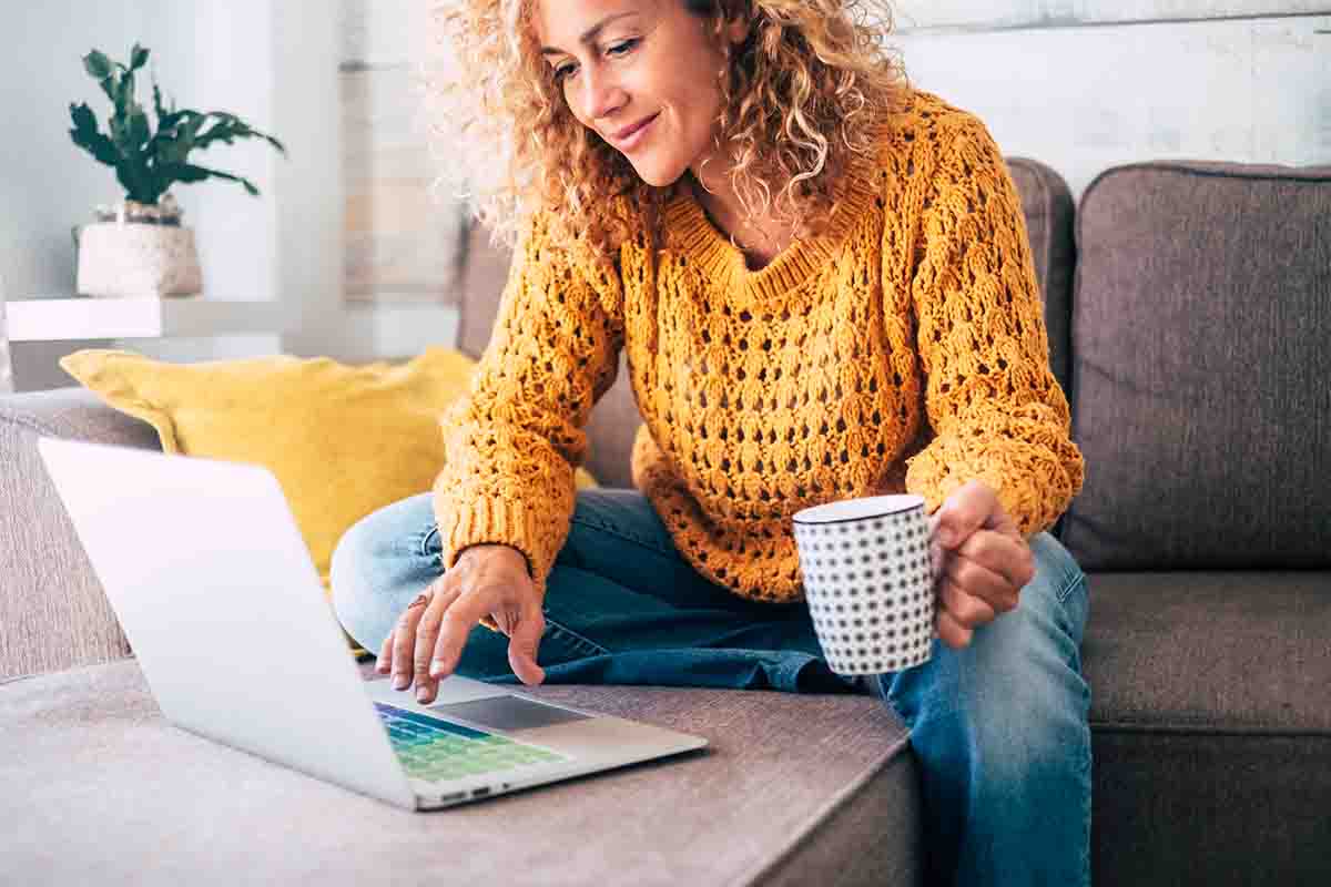 woman on couch with laptop learning about investing