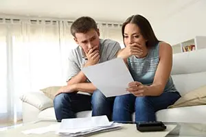 a man and woman looking worried while looking at papers