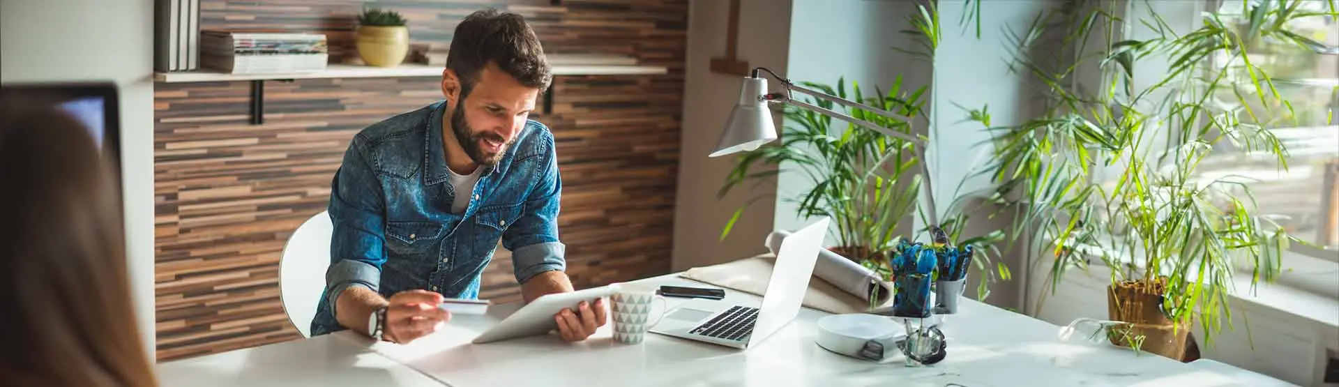 a man holding a credit card and looking at his bank account info