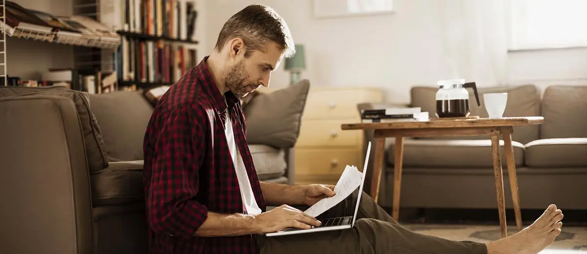 man in a red plaid shirt working on his budget