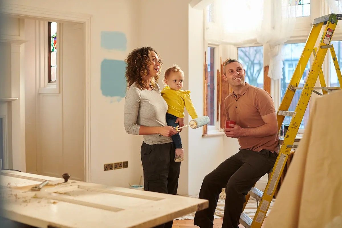 a man and woman with baby standing in a kitchen under construction