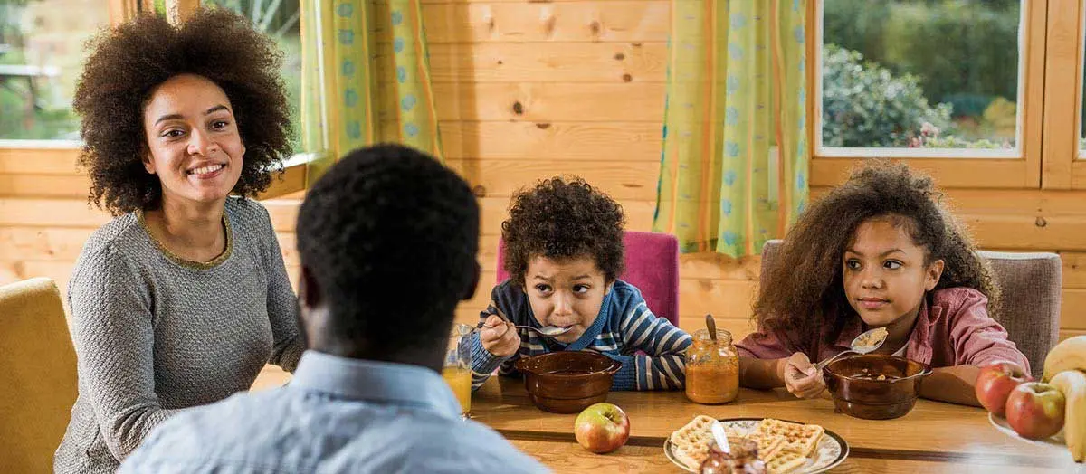 Family at home enjoying a snack at the dining table