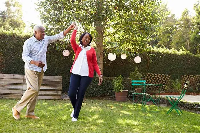 a retired couple dancing in their back yard