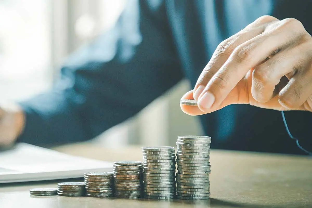 closeup of person counting quarters at a desk