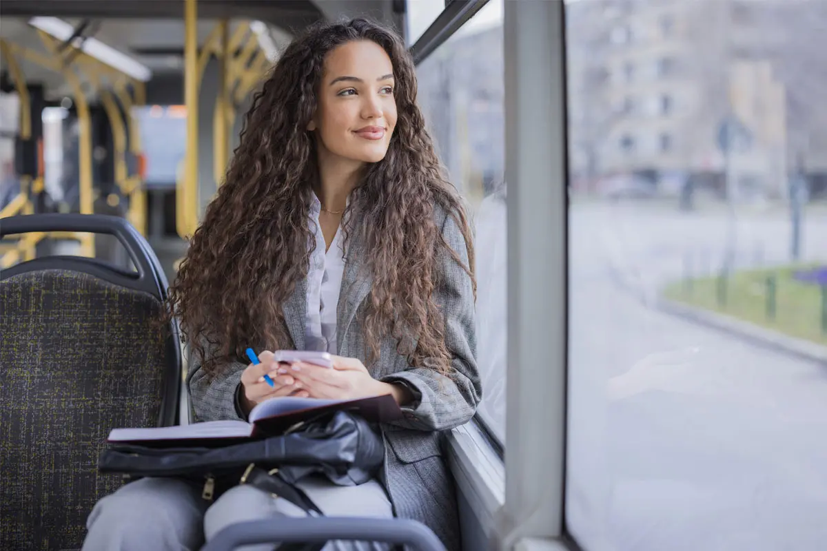woman holding a smartphone while riding the bus