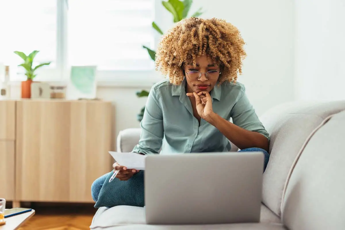 young woman working on computer while sitting on sofa